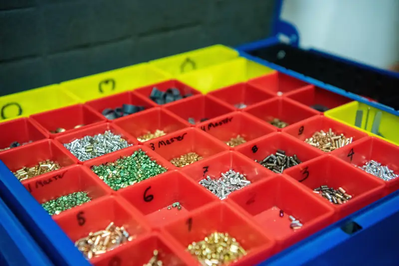 A locksmith's pin kit: a tray of small numbered compartments holding brass and silver lock pins of different lengths